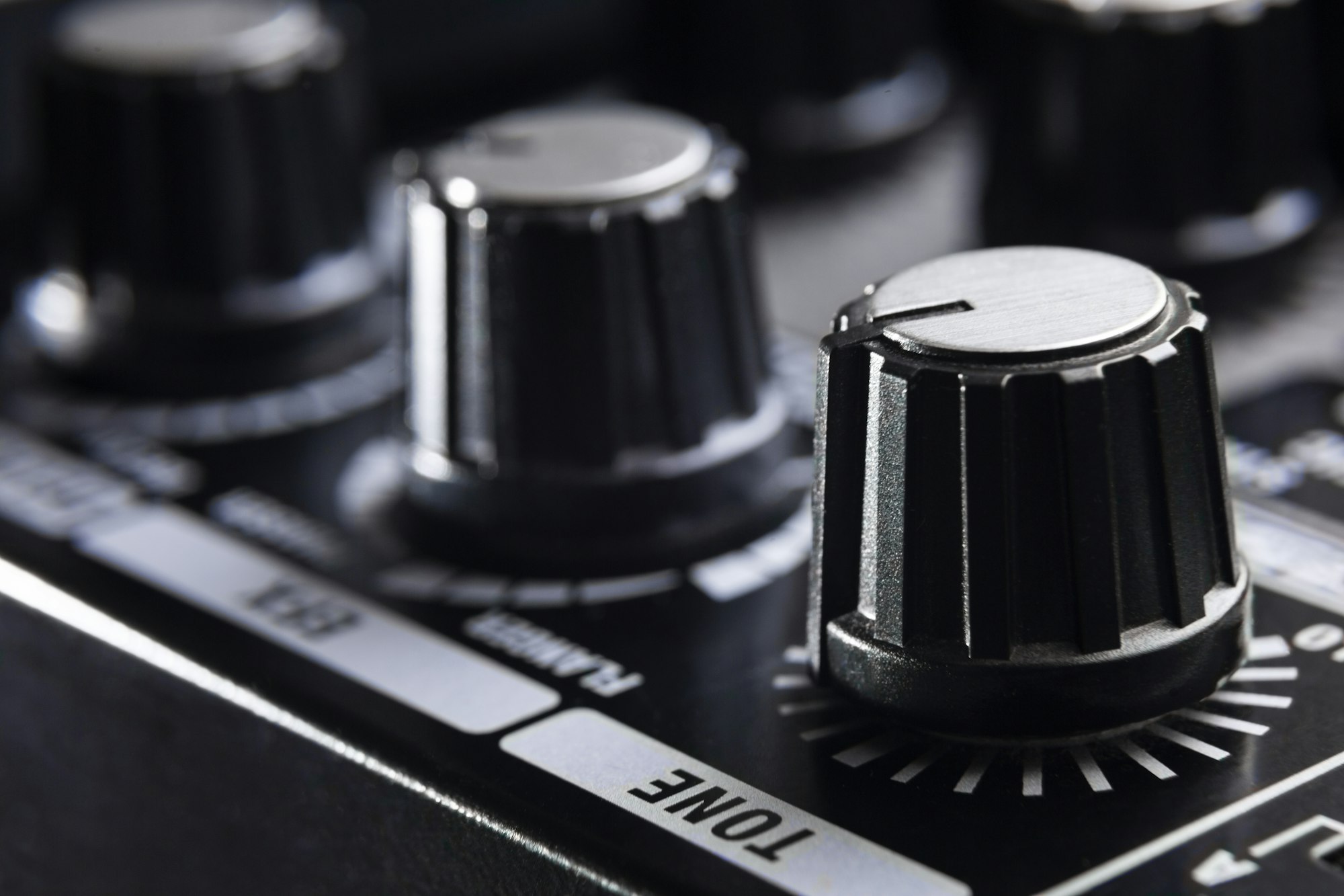 close-up detail of the adjustment knobs in the panel of an electric guitar amplifier