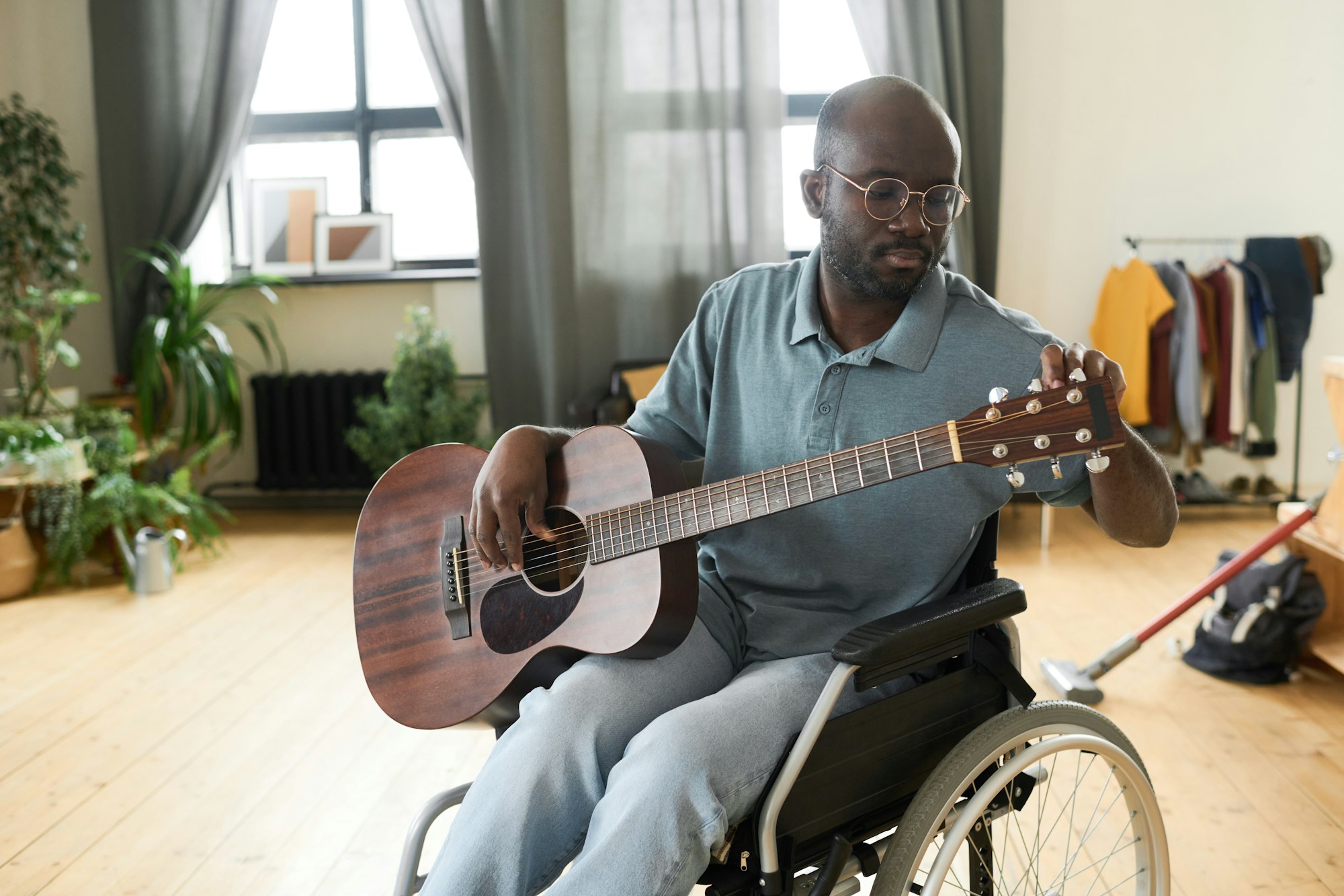 Disabled man tuning a guitar for playing