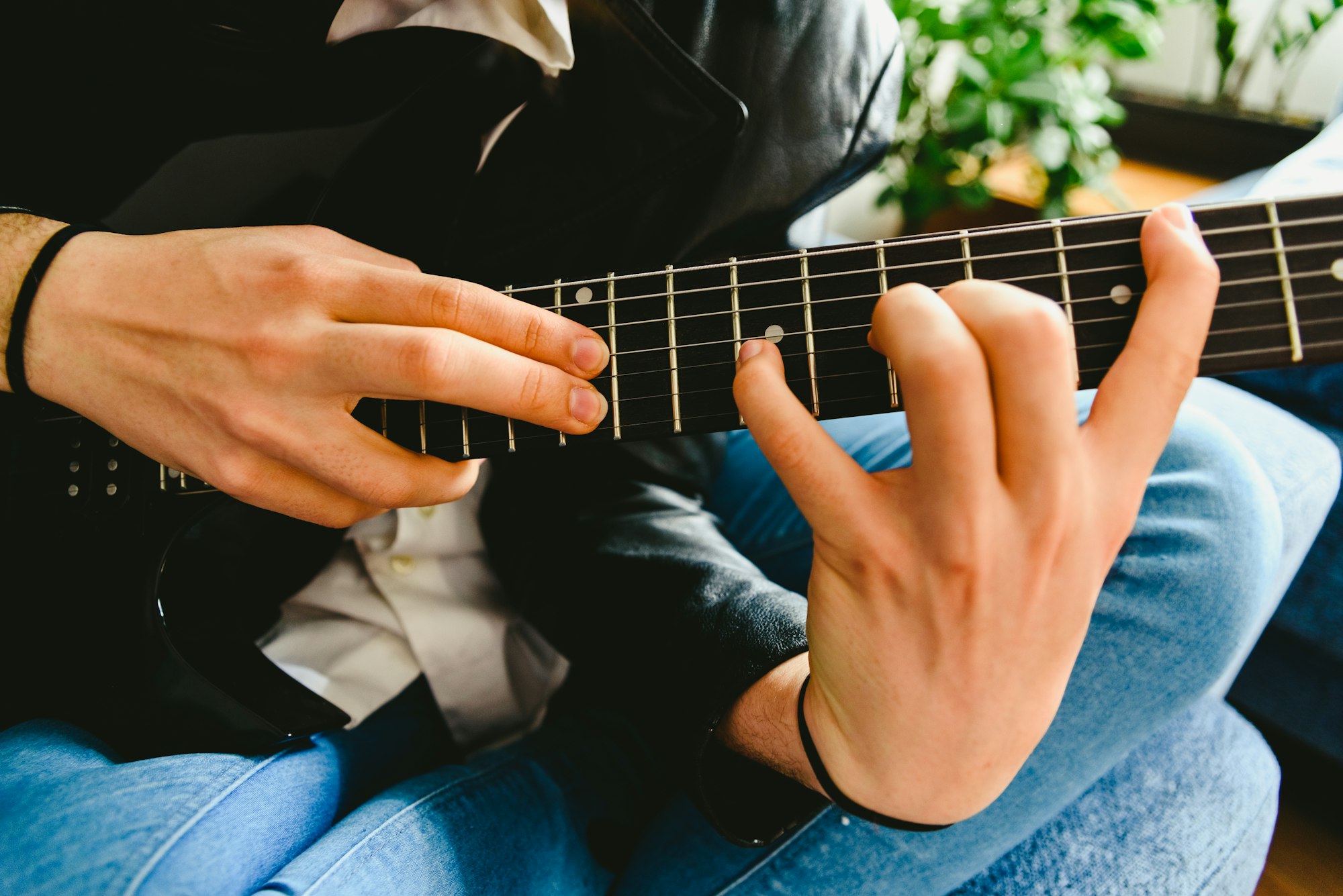 Electric guitar teacher teaching how to place fingers to play a chord.