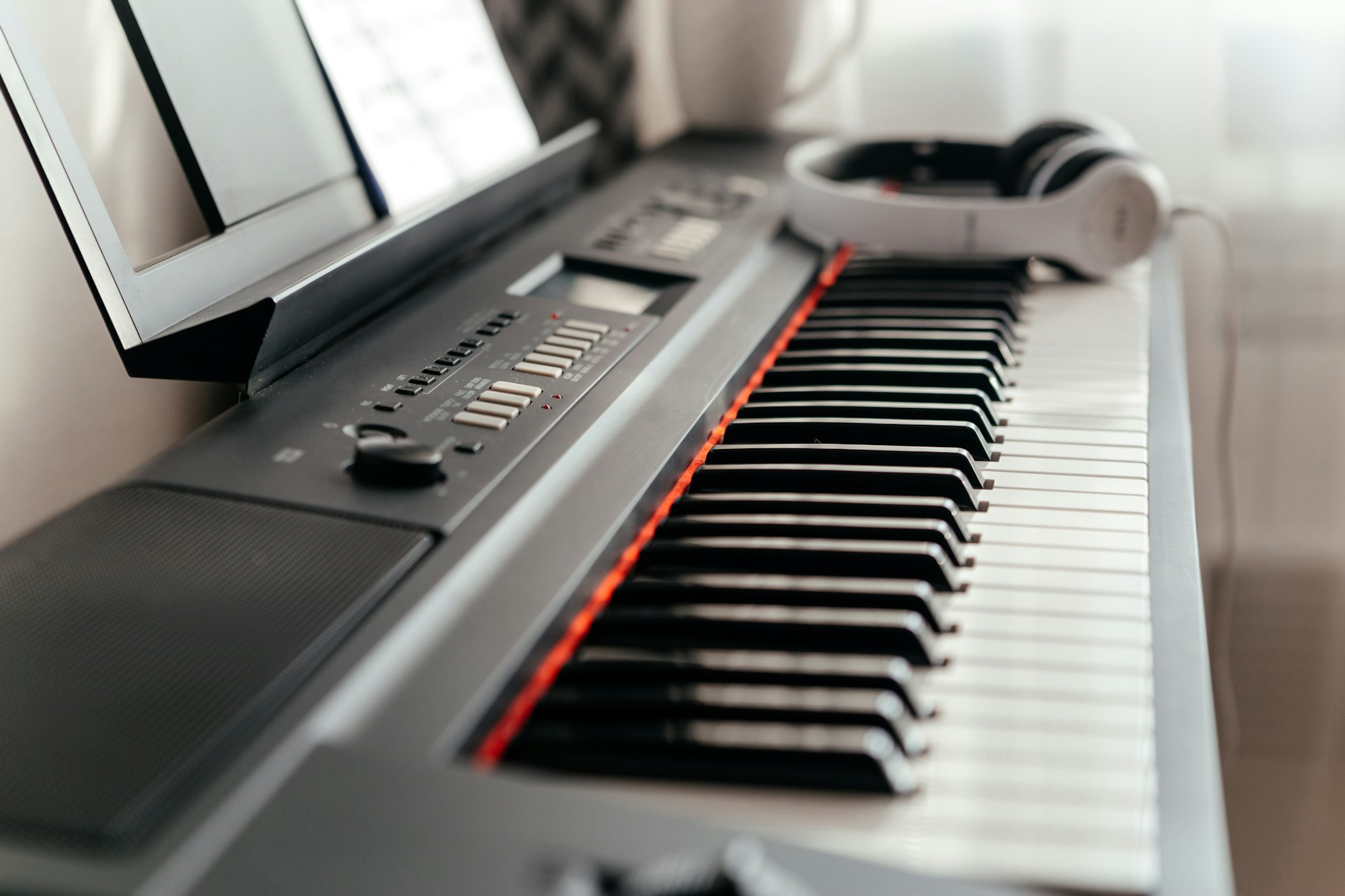 Electric piano keyboard, soft focus. Headphones on electronic piano