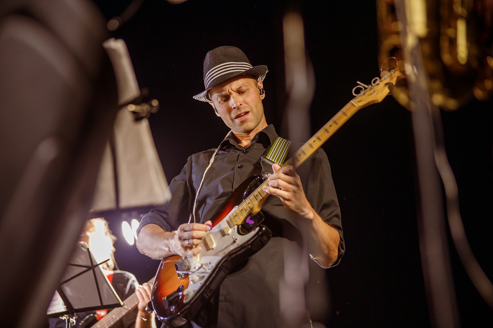 Handsome man playing guitar at night outdoor concert