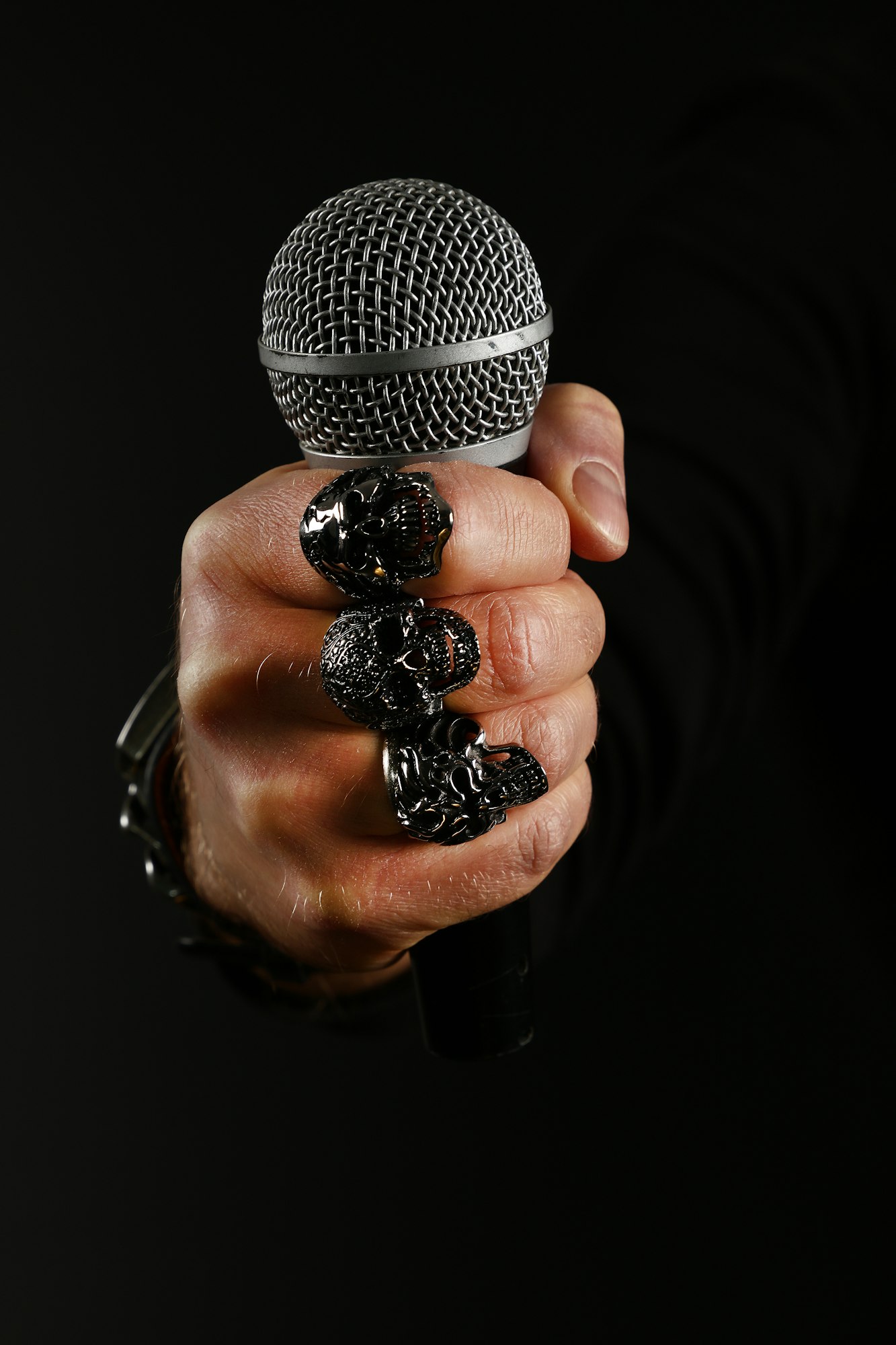 Man hand with microphone isolated on black