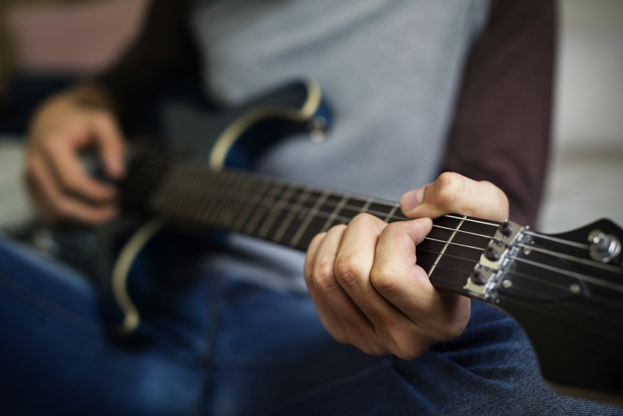 Teenage boy playing an electric guitar in a bedroom hobby and music concept