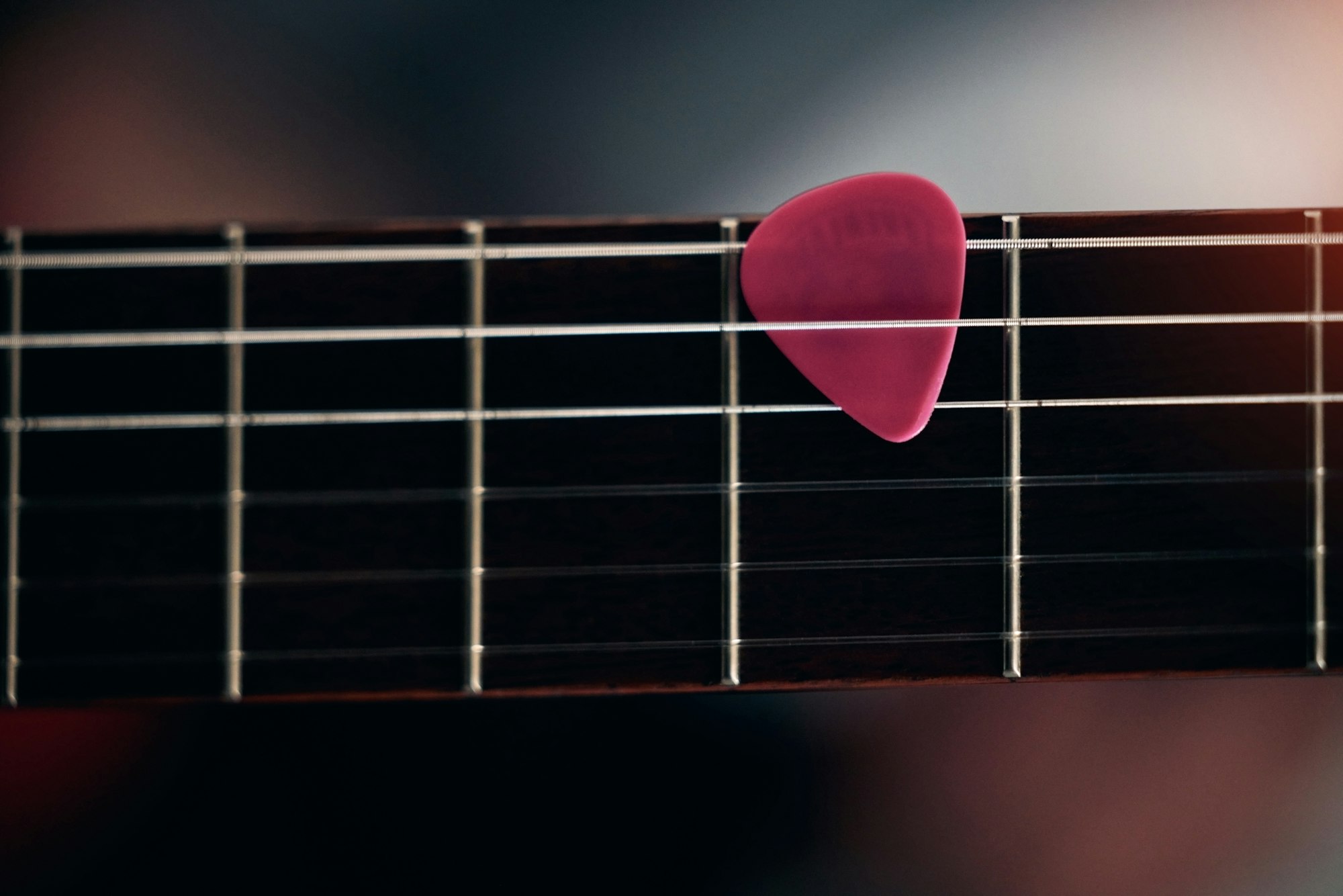 The pick of the bunch. Closeup shot of a guitar pick in between guitar sticks.