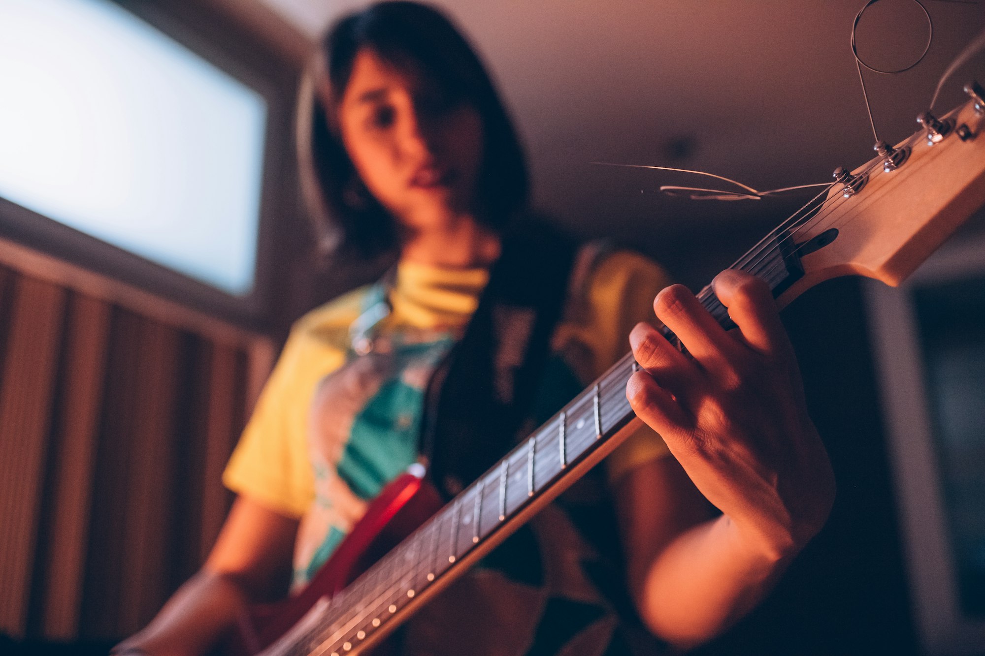 Young woman musician playing electric guitar